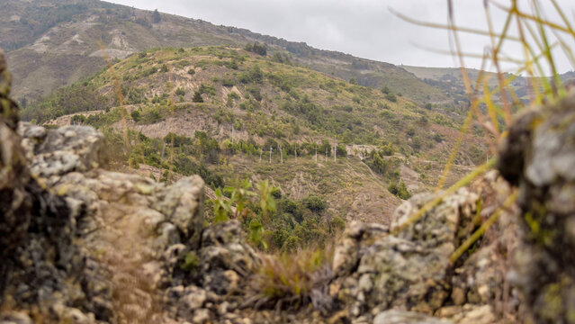In the distance, rustic wooden crosses standing in the middle of the mountain, as seeing from the steep edge of Pena Parida, a touristic hill in the town of Cucaita.