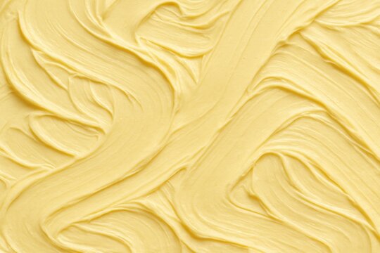 Smooth and creamy butter texture creating a wavy pattern, offering an enticing backdrop perfect for culinary or food related designs and illustrations