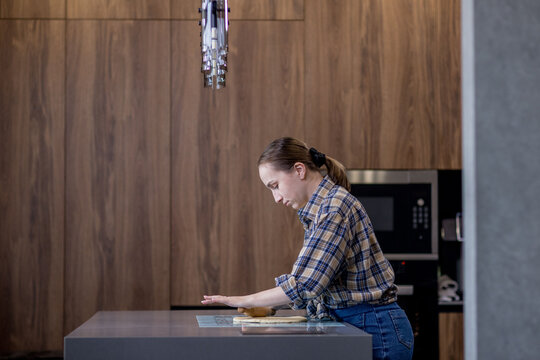 Woman skillfully rolls out dough, perfectly showcasing her culinary expertise in a kitchen