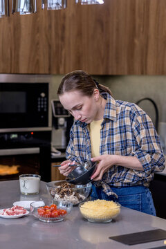 Young woman preparing quiche in the kitchen