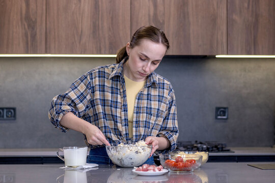 Young woman preparing quiche in the kitchen