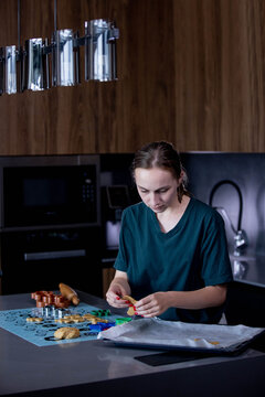 Young woman is making cookies in her kitchen