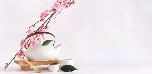 Composition with hot tea and blooming branch on white background with space for text