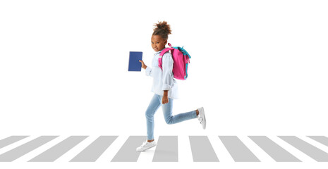 Jumping African-American schoolgirl with book on white background