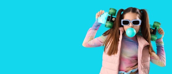 Stylish teenage girl with skateboard chewing gum on blue background with space for text