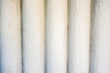 Close-up of a textured stone column surface with vertical grooves, showing rough architectural detail useful for backgrounds, textures, or design projects.