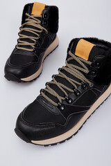 Women's fashion winter high-top sneakers with laces isolated on white background. Sports leather boots for female with fur. Shoes with thick sole. Luxury footwear mock up, template. Flat lay, top view