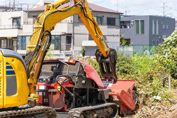 油圧ショベルと草刈り重機
