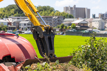 油圧ショベルと草刈り重機