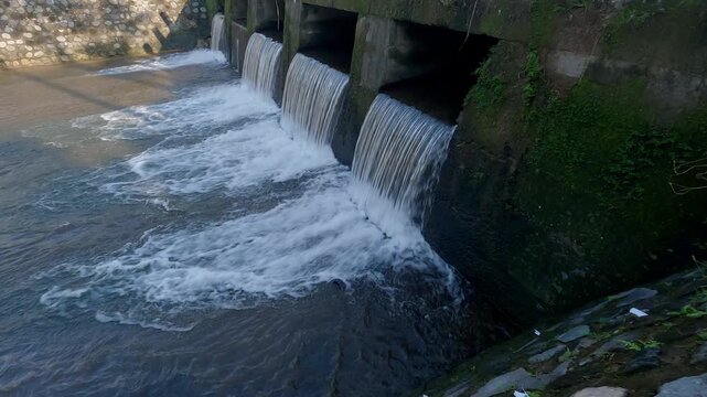 Water dam view in tropical countryside with bridge built structure. Panning right to left camera view