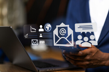 African modern professional managing a seamless multi-device workflow, synchronizing a corporate marketing campaign between a smartphone and laptop.