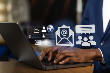 African business professional at work developing a corporate communication strategy and managing the company's global email marketing outreach on a laptop.