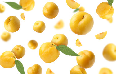 Fresh ripe cherry plums with green leaves falling on white background