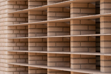 Abstract architectural background of brick wall with linear shelves and repetitive geometric structure. Minimalist perspective view symbolizing construction, design and order in modern architecture.