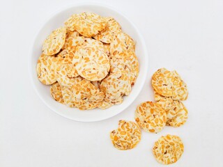 Tempeh chips in a white plate on a white background.