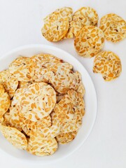 Tempeh chips in a white plate on a white background.