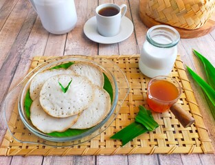 Serabi kuah, serabi with sweet coconut milk sauce in an isolated white plate. pancakes, serabi gravy, traditional Indonesian food.