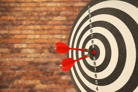 Red darts strike a target with great accuracy demonstrating skill