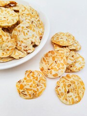 Close-up of tempeh chips in a white plate on a white background. 