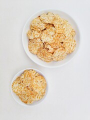 Tempeh chips in a white plate on a white background.