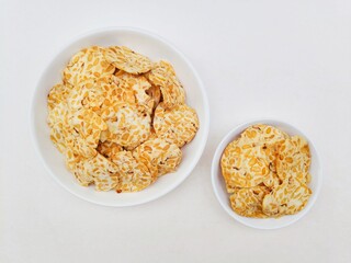 Tempeh chips in white plates on white background. Top of view. 