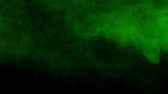 Subtle and soft green fog or smoke drifts slowly across dark screen. Atmospheric overlay for creating moody, mysterious, or eerie ambiance. For horror and fantasy