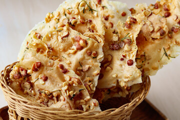 A tempting pile of crispy Rempeyek (or Peyek), a traditional Indonesian deep-fried cracker. Each piece is studded with peanuts and aromatic lime leaves, offering a delightful crunch and rich flavor.