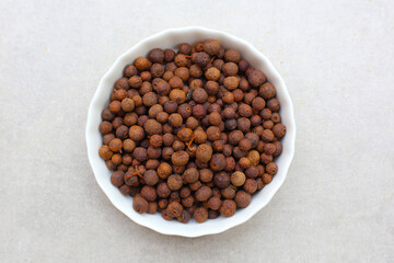 Brown dried allspice spice seeds.