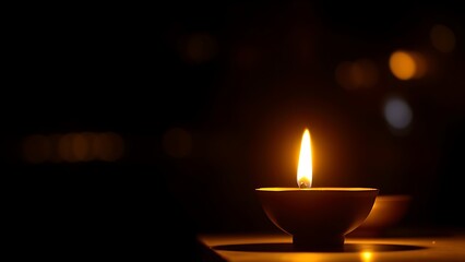Golden diya glowing in darkness, symbolizing tradition and festive spirit in Indian culture.