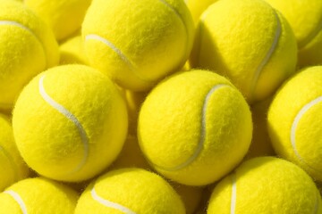 A vibrant pile of fuzzy yellow tennis balls creates a textured and energetic visual composition.