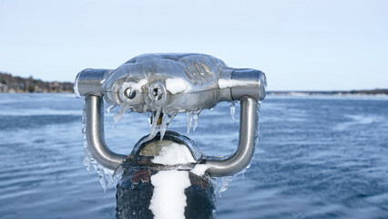 Obraz premium Frozen View Through a Public Telescope Sights Overlooking Icy Lake