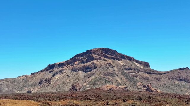 The breathtaking view of a rocky mountain, set against a vibrant blue sky, is truly perfect for avid nature lovers