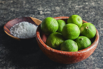 Limes and salt in Clay bowls resting on marble countertop