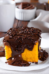 Slice of carrot cake with chocolate frosting on a ceramic plate. homemade Brazilian dessert