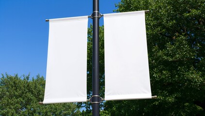 Blank white banners on a pole in front of trees