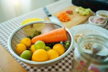 Fresh raw cooking ingredients, chopped carrot, lime, and meat on wooden cutting board.