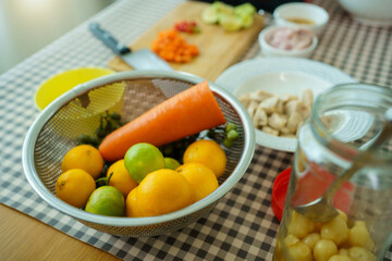 Fresh raw cooking ingredients, chopped carrot, lime, and meat on wooden cutting board.