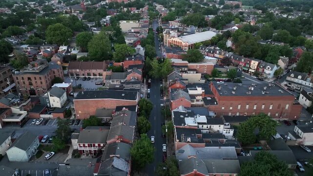 Cars on main street of American city at dusk. Colored townhouses and row homes in Lancaster, Pennsylvania. Cloudy summer day in small city of Pennsylvania. Aerial Birds Eye shot.