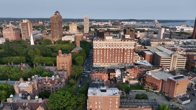 Aerial wide shot of Yale old campus university of New Haven. American City in Connecticut at sunset. Summer day with green trees. Connecticut Financial Center and Long Island Sound in downtown, USA.