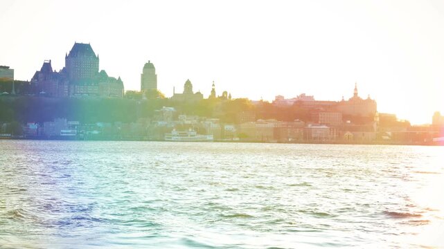 Skyline of Quebec City as seen from across the St. Lawrence River in Levis, Quebec, Canada. Shot during sunset with a rainbow lens flare. 2017.