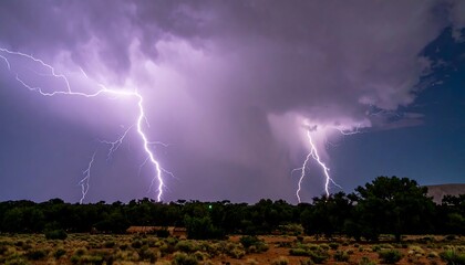 Fototapeta premium Dramatic Lightning Strikes Illuminate a Stormy Night Sky Over a Desert Landscape.