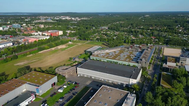 Modern film studios with offices and sound stages surrounded by trees in Berlin Adlershof, Germany. Perfect aerial view flight speed ramp hyper motion time lapse fly push forward drone