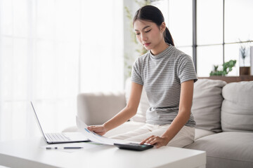 Asian Woman Pressing calculator for
 financial planner remotely Personal finance at home.