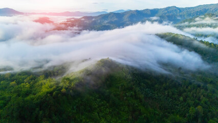 Aerial view from above of white puffy clouds Flying through the clouds above mountain tops.