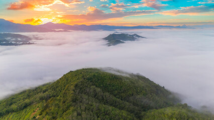 Aerial view from above of white puffy clouds Flying through the clouds above mountain tops.