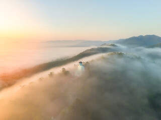 Aerial view from above of white puffy clouds Flying through the clouds above mountain tops.