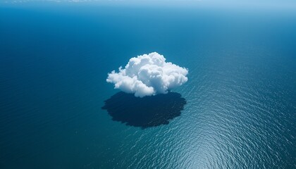 Tranquil seascape featuring a solitary white cloud reflecting in the calm, deep blue ocean surface.