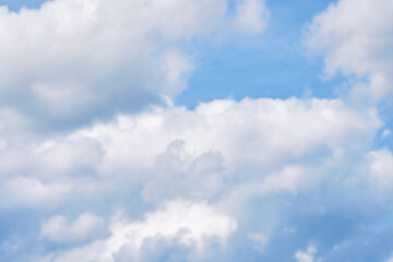 Bright fluffy clouds drifting in a clear blue sky on a sunny afternoon