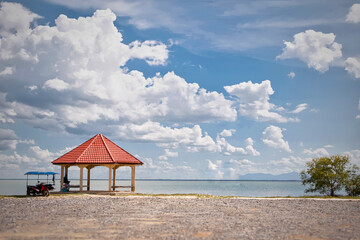 The pavilion, staying in an orange, is on the sea.