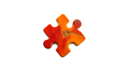 Close up of a single puzzle piece with red and orange colors on a black background in studio shot